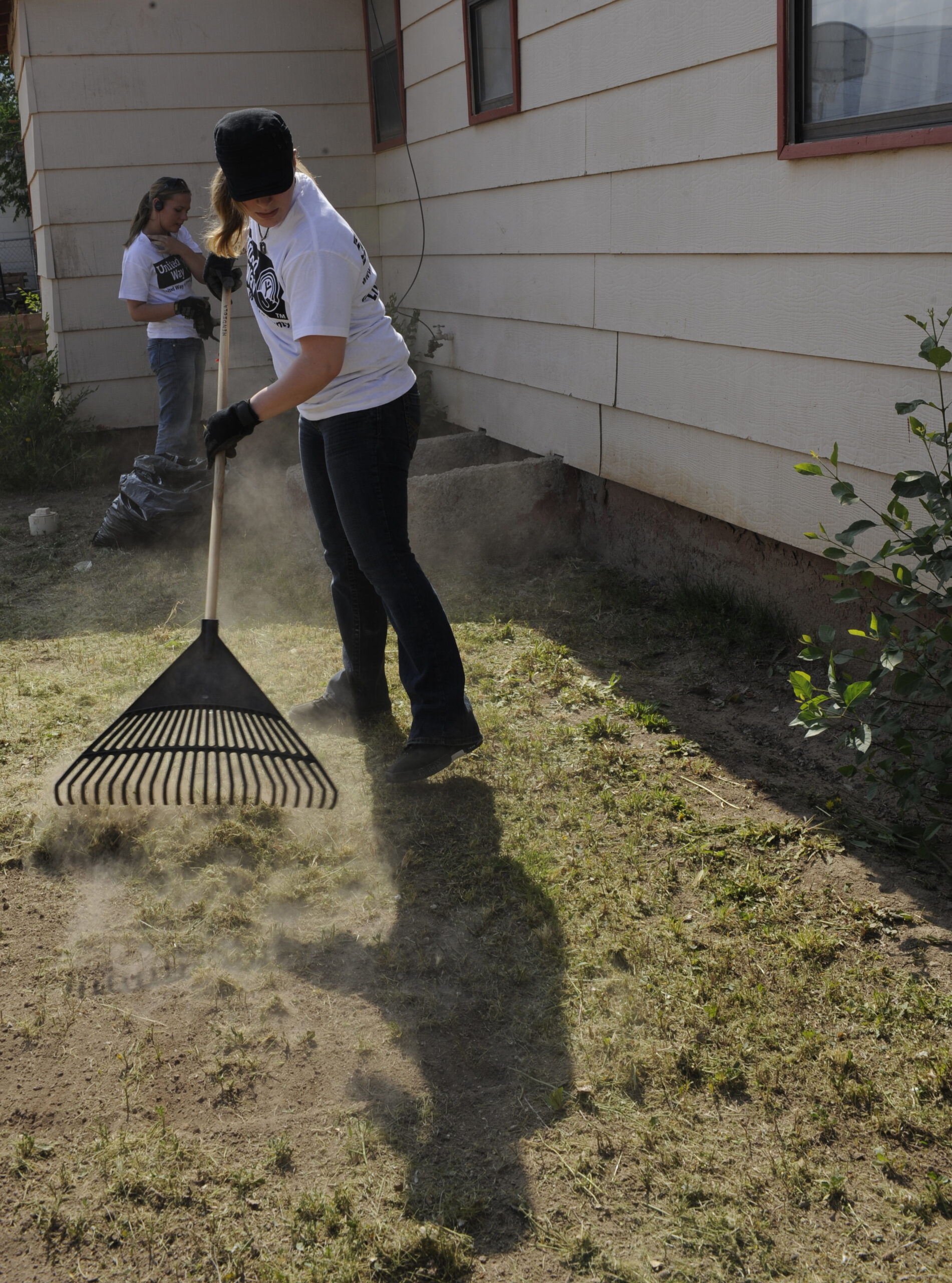 ALAMOGORDO, N.M.  Senior Airman Kristen Miller, from the 49th Communications Squadron at Holloman Air Force Base, rakes grass after mowing the lawn at an Alamogordo home during the United Way Day of Caring May 14, 2010. Members of Team Holloman performed a variety of jobs during the annual volunteering event, from mowing lawns, trimming trees, pulling weeds and painting homes, in an effort to help out the local community.  (U.S. Air Force photo by Airman 1st Class Eileen Payne / Released)