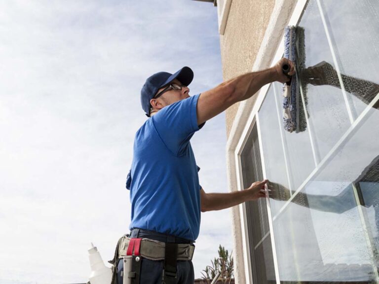 Man cleaning window of a home.